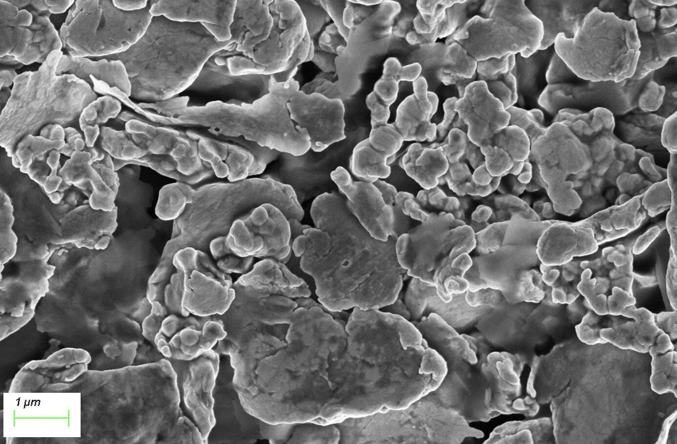 Scanning electron microscope image of a macroscopic filler composite with large agglomerated particles and irregular micron-scale structures.